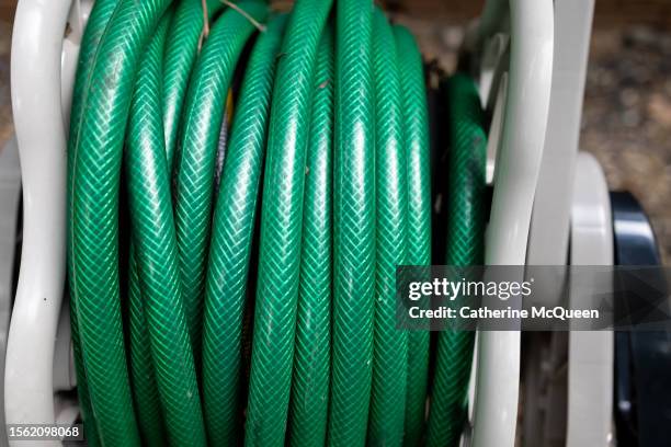 coiled outdoor garden hose in storage unit - tying stock pictures, royalty-free photos & images