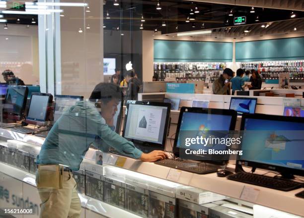 Shopper looks at a desk top computer at an electronics store in the Sanlitun area of Beijing, China, on Friday, Nov. 9, 2012. China's retail sales...