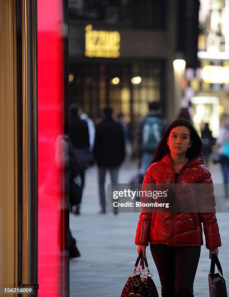 Woman walks in the Sanlitun area of Beijing, China, on Friday, Nov. 9, 2012. China's retail sales exceeded forecasts and inflation unexpectedly...