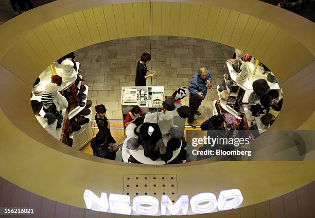 Shoppers look at hats at a store in Beijing, China, on Saturday, Nov. 10, 2012. China's retail sales exceeded forecasts and inflation unexpectedly...