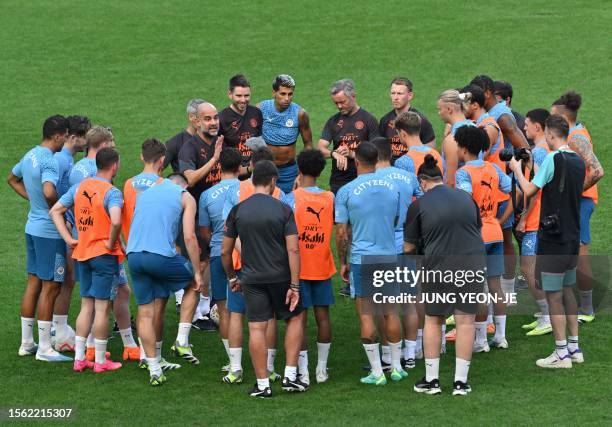 Manchester City's head coach Pep Guardiola speaks with the players during a training session at the Seoul World Cup Stadium in Seoul on July 29 on...