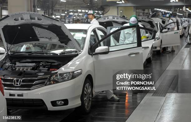 Thai employees work at a Japan's car manufacturer Honda production line after its re-opening in Ayutthaya province on March 31, 2012. The months-long...