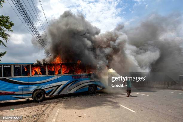 Bangladesh Nationalist Party activists set a bus on fire as they block a highway in Dhaka on July 29 while they protest asking for Prime Minister...