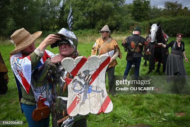 Steve Morris as 'Sir Lancelot' is helped by his squire to remove his helmet after competing in the Legendary Joust jousting event at English...