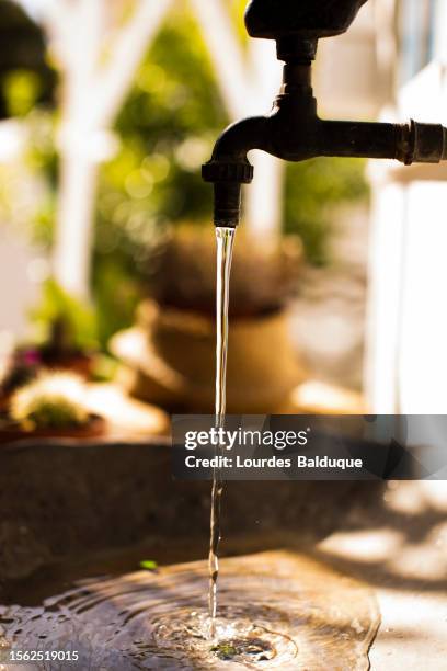 closeup of water jet in old metal faucet - decoración stockfoto's en -beelden