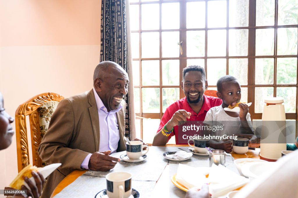 Relaxed family members laughing at dining table