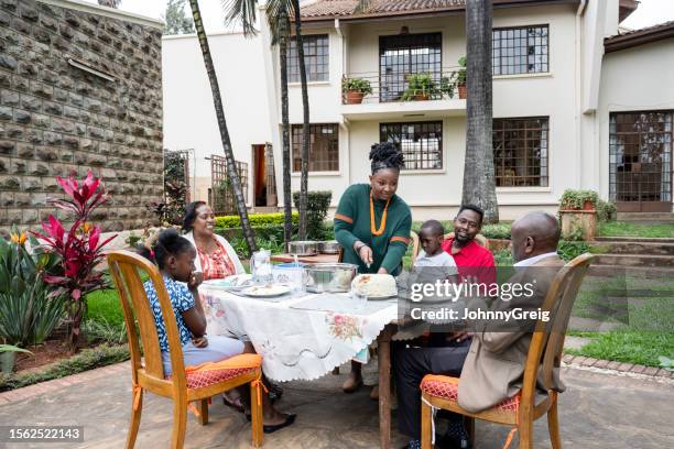 multi-generation nairobi family eating meal outdoors - child eating cereal stock pictures, royalty-free photos & images