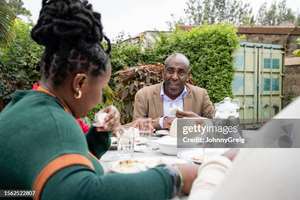 black family members conversing during outdoor meal - child eating cereal stock pictures, royalty-free photos & images