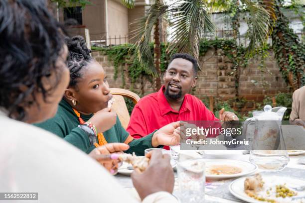 candid view of black family eating lunch in home garden - child eating cereal stock pictures, royalty-free photos & images