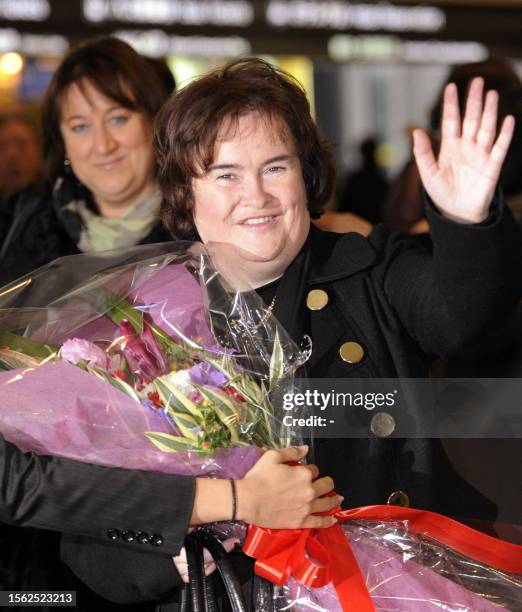 Scottish singer Susan Boyle receives a flower bouquet upon her arrival at the Narita International Airport in Narita city in Chiba prefecture on...