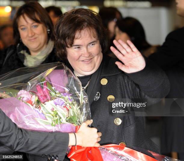 Scottish singer Susan Boyle receives a flower bouquet upon her arrival at the Narita International Airport in Narita city in Chiba prefecture on...