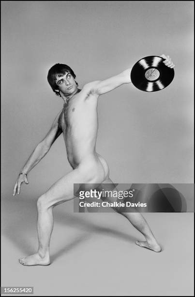 English multi-instrumentalist and composer Mike Oldfield poses nude, holding a record in a discus-throwing stance, to promote his double album...