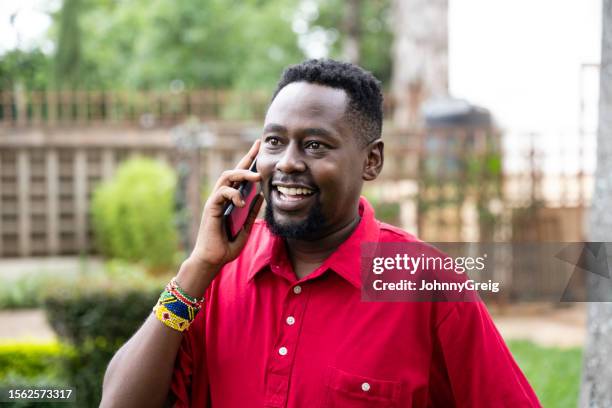 casually dressed african businessman using smart phone - three quarter front view stock pictures, royalty-free photos & images