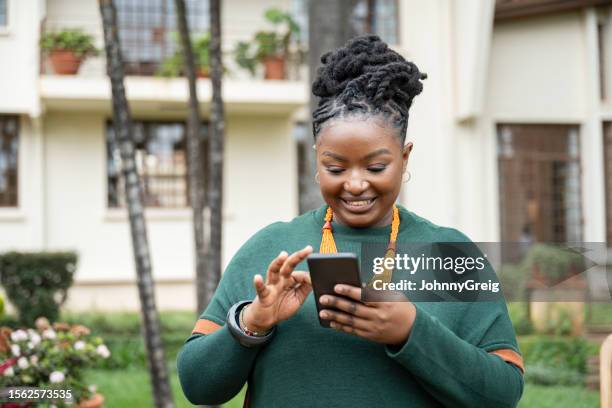 young african woman searching internet on smart phone - sub saharan africa stock pictures, royalty-free photos & images