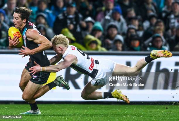 Connor Rozee of Port Adelaide breaks a John Noble of the Magpies tackle during the round 19 AFL match between Port Adelaide Power and Collingwood...