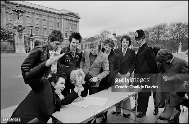 English punk group the Sex Pistols, with their manager Malcolm McLaren , sign their recording Contract with A&M outside Buckingham Palace, London,...