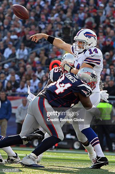 Patriots defenders Justin Francis and Brandon Spikes , rear, combine to sandwich Bills quarterback Ryan Fitzpatrick just as he gets off an incomplete...