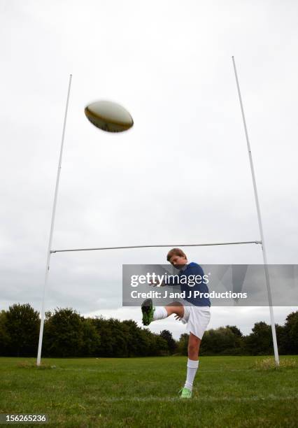 boy kicking a rugby ball - rugby ball kick stock pictures, royalty-free photos & images