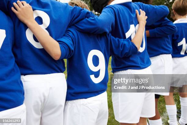 boys in a line from behind - maillot de sport photos et images de collection