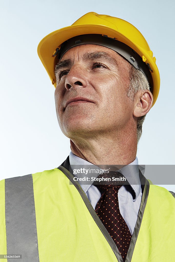 Businessman wearing hard hat and high vis jacket