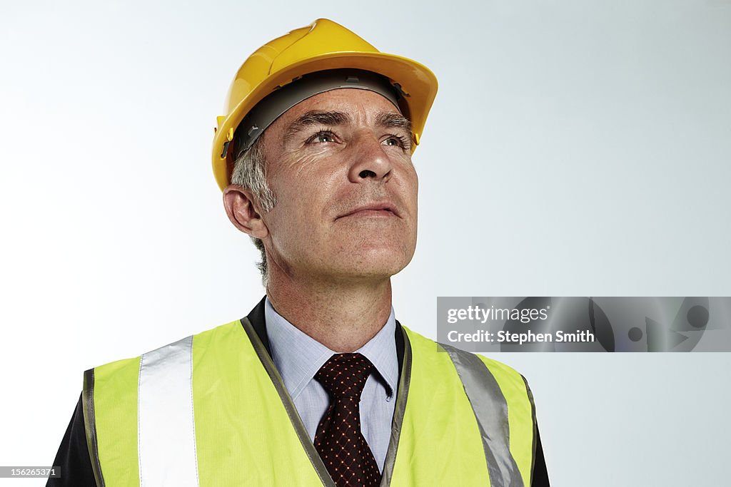 Businessman wearing hard hat and high vis jacket