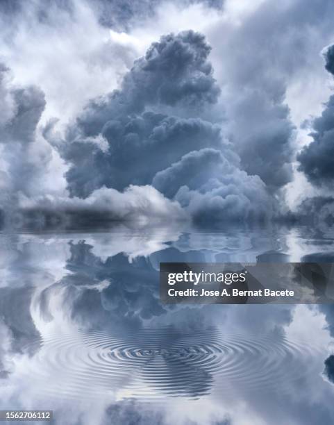 white storm clouds reflected on a water surface. - condições meteorológicas extremas imagens e fotografias de stock