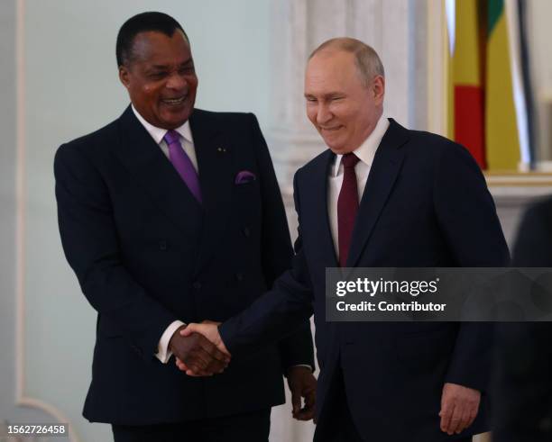 Russian President Vladimir Putin greets Republic of Congo's President Denis Sassou Nguesso during their bilateral meeting, on July 29 in Saint...