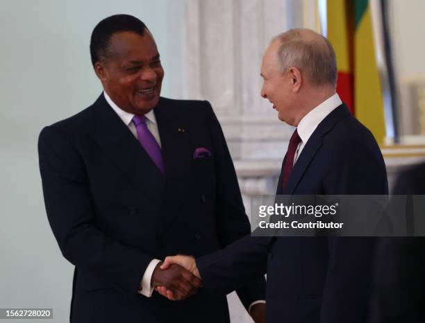 Russian President Vladimir Putin greets Republic of Congo's President Denis Sassou Nguesso during their bilateral meeting, on July 29 in Saint...