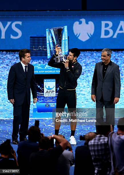 Novak Djokovic of Serbia kisses the trophy after being presented with it in front of photographers by Ashok Vaswani , Chief Executive of Barclays...