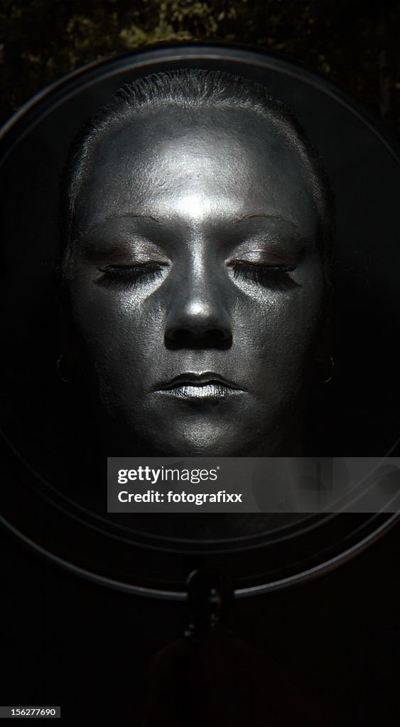 Woman Face Painted Silver in Mirror