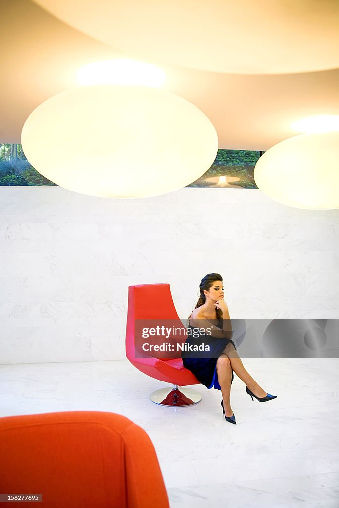 Woman Sitting in Red Chair