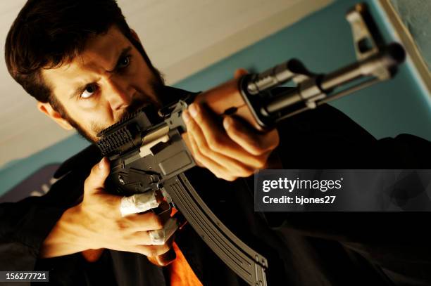 angry man holding semi-automatic rifle - kalasjnikov stockfoto's en -beelden