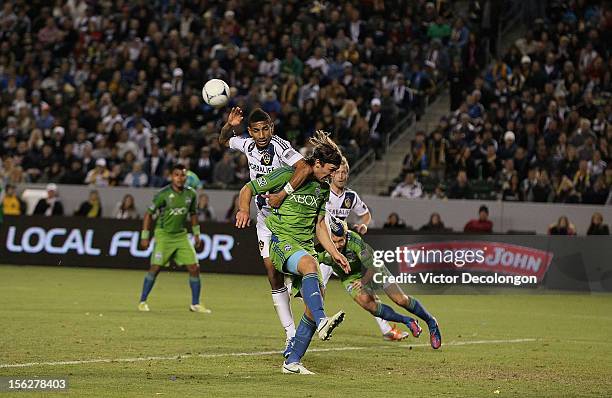 Sean Franklin of the Los Angeles Galaxy and Jeff Parke of the Seattle Sounders vie for position in the goal box as Adam Johansson of the Seattle...