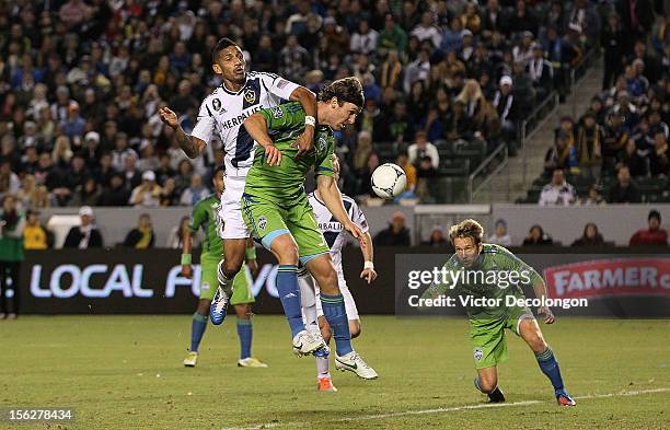 Sean Franklin of the Los Angeles Galaxy and Jeff Parke of the Seattle Sounders vie for position for the cross into the goal box as Adam Johansson of...