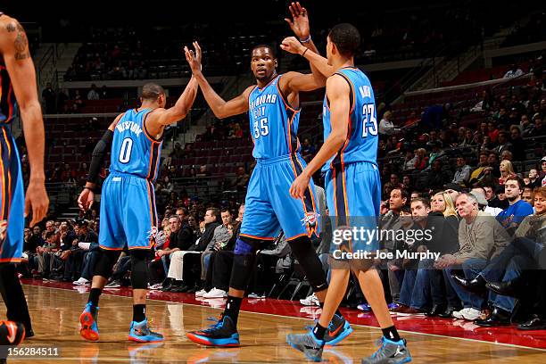 Kevin Durant of the Oklahoma City Thunder is congratulated by teammates Russell Westbrook and Kevin Martin while playing the Detroit Pistons on...