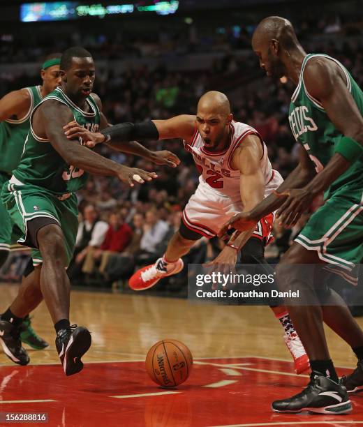 Taj Gibson of the Chicago Bulls looses control of the ball between Brandon Bass and Kevin Garnett of the Boston Celtics at the United Center on...
