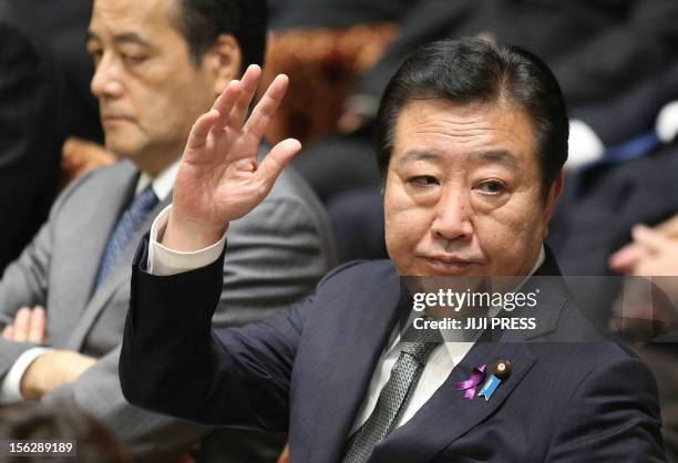Japanese Prime Minister Yoshihiko Noda raises his hand to answer a question at the Lower House's budget committee session at the National Diet in...