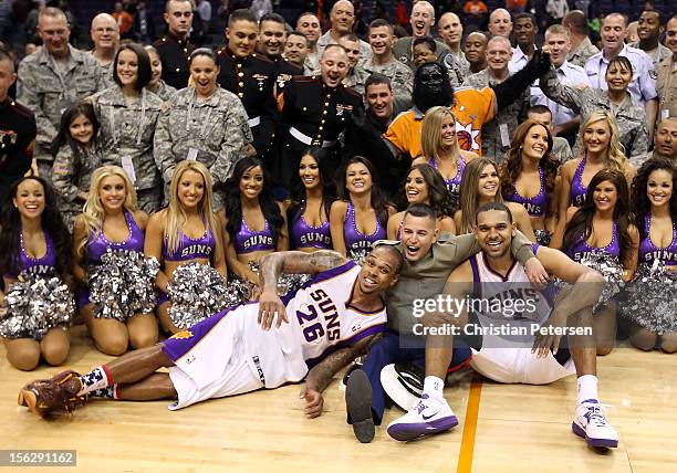 Shannon Brown and Jared Dudley of the Phoenix Suns pose with members of the military and cheerleaders in honor of Military Appreciation Night...