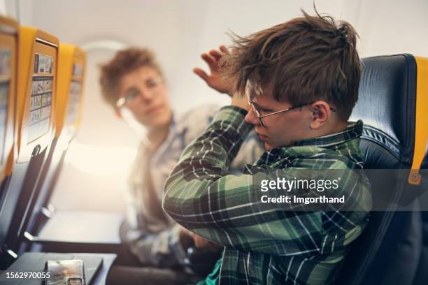 naughty teenage kids travelling by plane - angry boy stockfoto's en -beelden
