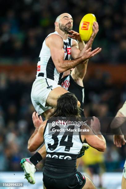 Steele Sidebottom of the Magpies marks in front of Lachie Jones of Port Adelaide during the round 19 AFL match between Port Adelaide Power and...