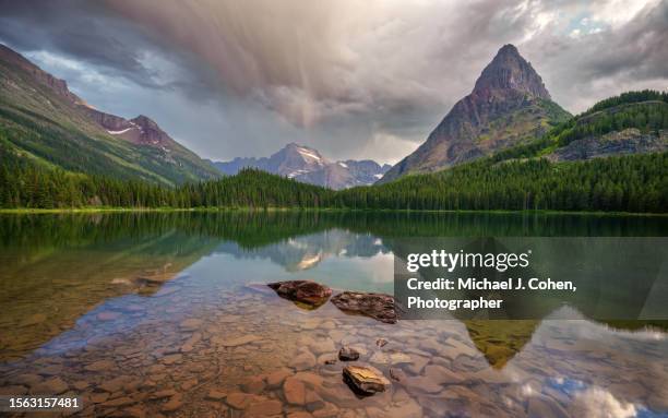 swiftcurrent lake, glacier - atmosferische lucht stockfoto's en -beelden