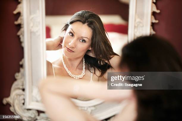 woman putting pearl necklace - pearl necklace stockfoto's en -beelden