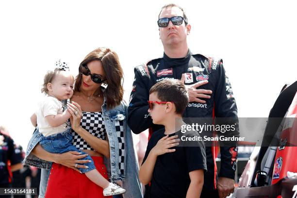 Kyle Busch, driver of the Zariz Transport Chevrolet, stands on the grid during the national anthem with his wife, Samantha Busch, daughter, Lennix...