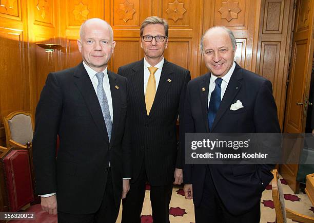 German Foreign Minister Guido Westerwelle poses with his counterparts from Great Britain William Hague and from France Laurent Fabius before the...