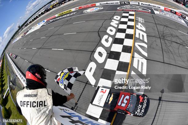 Kyle Busch, driver of the Zariz Transport Chevrolet, takes the checkered flag to win the NASCAR Craftsman Truck Series CRC Brakleen 150 at Pocono...
