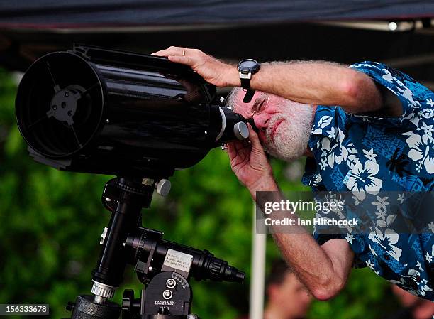 Terry Cuttle uses a telescope to watch the total solar eclipse on November 14, 2012 in Palm Cove, Australia. Thousands of eclipse-watchers have...