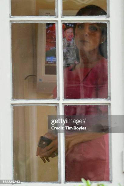 Jill Kelley looks out the window of her home as Gen. David H. Petraeus is seen on the television in the background on November 13, 2012 in Tampa,...