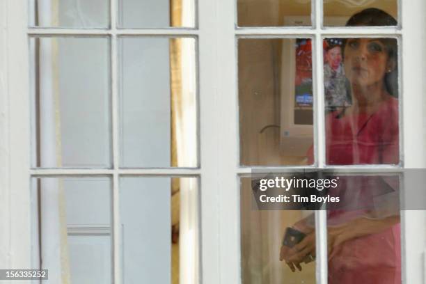 Jill Kelley looks out the window of her home as Gen. David H. Petraeus is seen on the television in the background on November 13, 2012 in Tampa,...