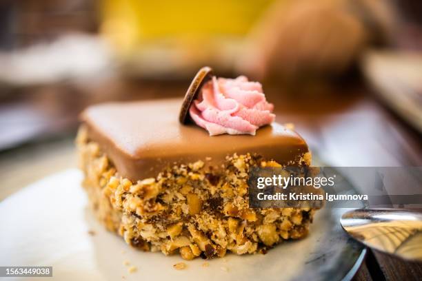 cake with nuts, nougat and caramel decorated with a sweet creamy rose - almond caramel stock pictures, royalty-free photos & images