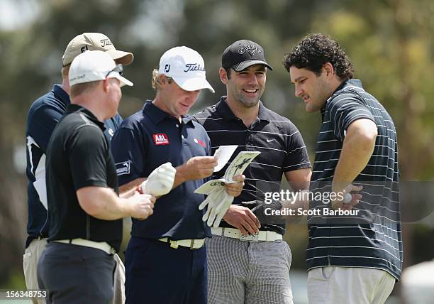 Former AFL footballer Brendan Fevola and rugby league player Cameron Smith stand with Peter Wilson of Australia during the Pro-Am Day ahead of the...